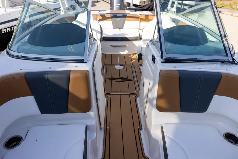 Slide: The Image of 2023 Chaparral 21 SSi OB boat interior with tan and black seating, sleek design. - 12