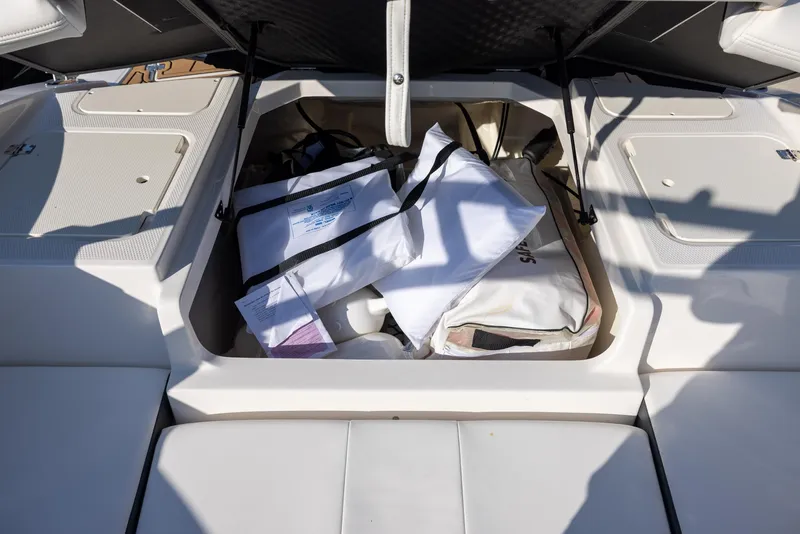 Slide: The Image of 2023 Chaparral 21 SSi OB boat storage compartment with bags and gear. - 8