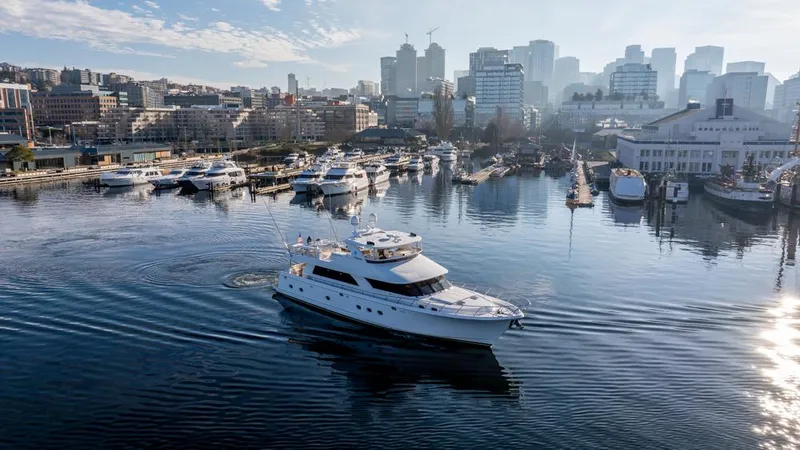 Slide: The Image of Ocean Alexander 80' Motoryacht (2010) cruising in a marina with city skyline backdrop. - 1