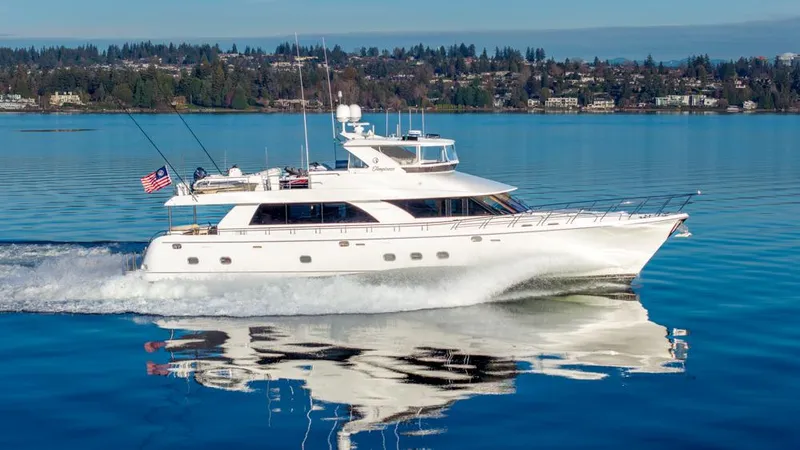 Slide: The Image of 2010 Ocean Alexander 80' Motoryacht cruising on a serene lake with a scenic backdrop. - 3