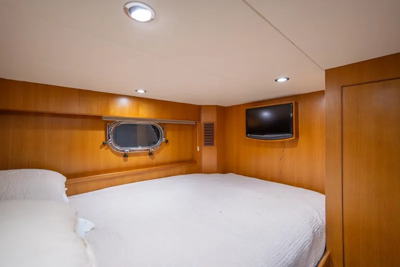Slide: The Image of Luxurious bedroom in 2010 Ocean Alexander 80' Motoryacht with wood paneling and porthole window. - 43