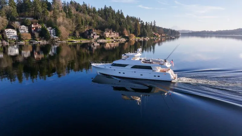 Slide: The Image of Luxurious 2010 Ocean Alexander 80' Motoryacht cruising on a serene lake with forested shoreline. - 7