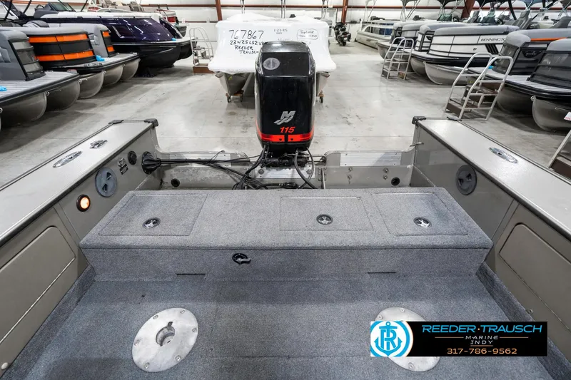 Slide: The Image of 2001 Lund 1775 Pro V SE boat interior with motor, in a showroom setting. - 19