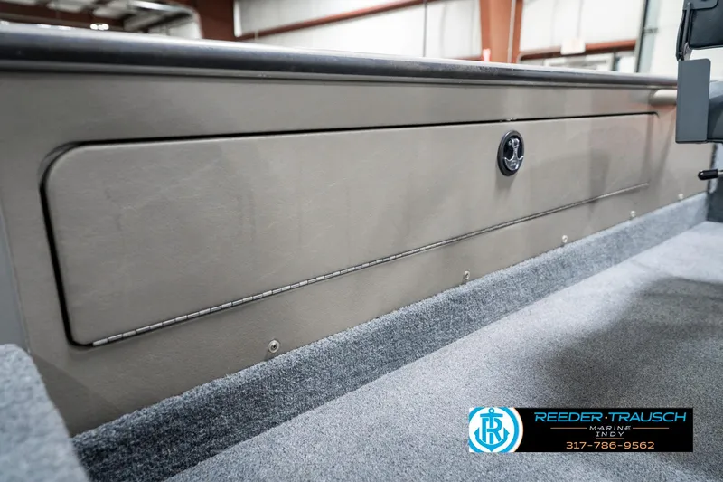 Slide: The Image of 2001 Lund 1775 Pro V SE boat interior storage compartment with lock, carpeted floor, and dealership logo. - 27