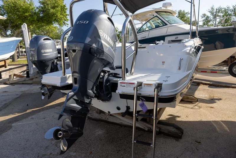 Slide: The Image of 2022 Hurricane SunDeck Sport 205 OB boat with Yamaha 150 outboard motor, docked outdoors. - 2