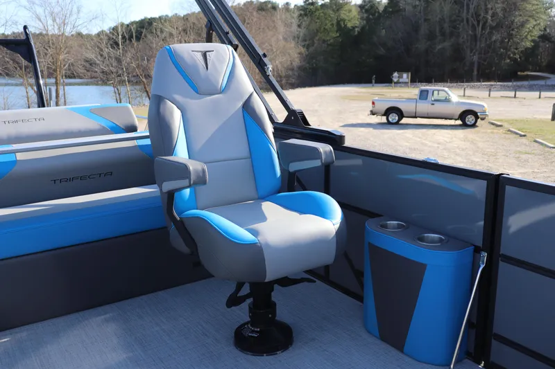 Slide: The Image of 2025 Trifecta 23 ULE boat interior with blue and gray captain's chair, cup holders, and scenic background. - 5