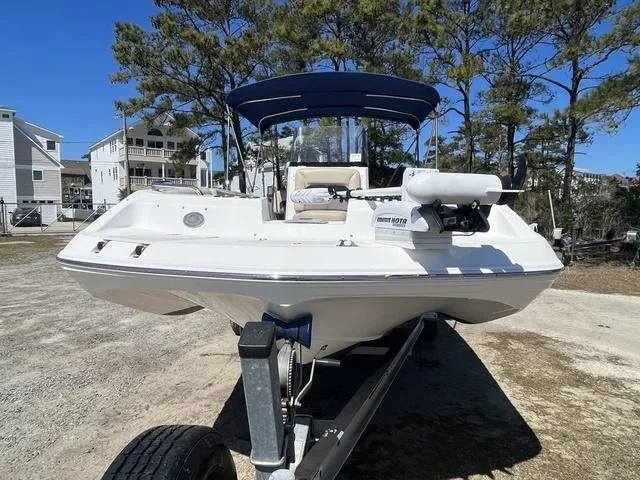 Slide: The Image of 2016 Hurricane CC 19 OB boat on trailer, parked outdoors under clear blue sky. - 2