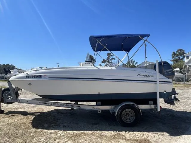 Slide: The Image of 2016 Hurricane CC 19 OB boat on trailer with blue canopy, parked outdoors. - 3