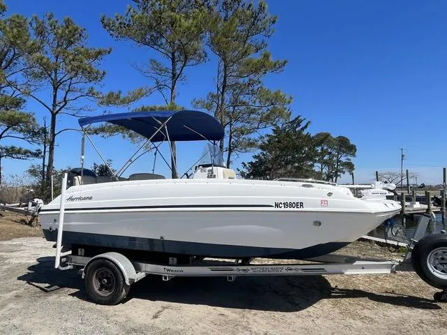 Slide: The Image of 2016 Hurricane CC 19 OB boat on trailer with blue canopy, parked outdoors. - 1