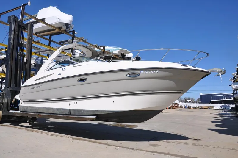 Slide: The Image of 2008 Monterey 270 Cruiser boat on forklift, displayed outdoors under clear blue sky. - 0