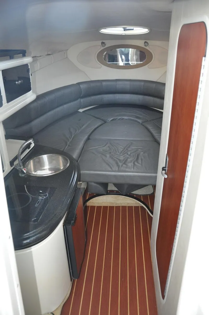 Slide: The Image of 2008 Monterey 270 Cruiser interior with kitchenette, seating, and wood accents. - 16