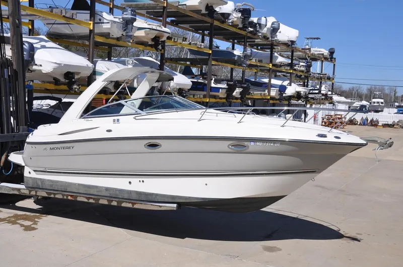 Slide: The Image of 2008 Monterey 270 Cruiser boat in storage yard, surrounded by stacked boats. - 2