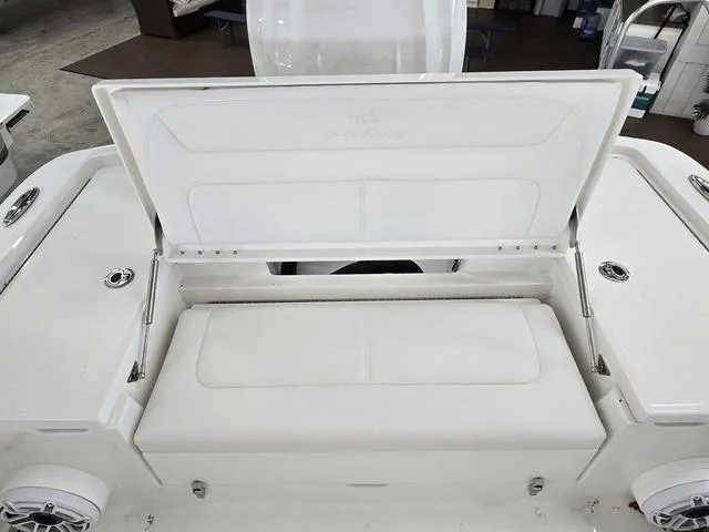 Slide: The Image of 2025 Regulator 24XO boat with open storage compartment and cushioned seating. - 8