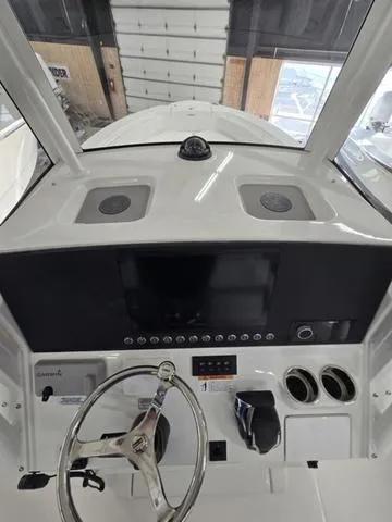 Slide: The Image of 2025 Regulator 26XO boat dashboard with steering wheel and control panel. - 12