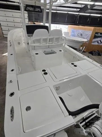 Slide: The Image of 2025 Regulator 26XO boat interior with seating and storage compartments in a showroom. - 5