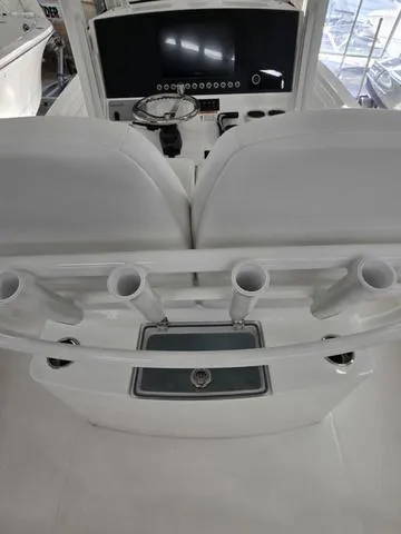 Slide: The Image of 2025 Regulator 26XO boat interior with helm, rod holders, and seating. - 7