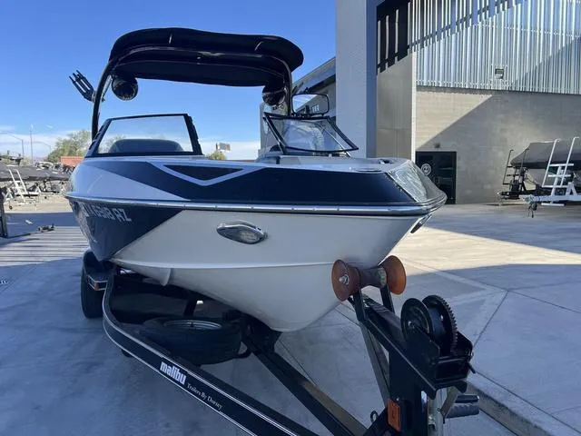 Slide: The Image of 2009 Malibu Wakesetter 23 LSV boat on trailer, parked outdoors near a building. - 3