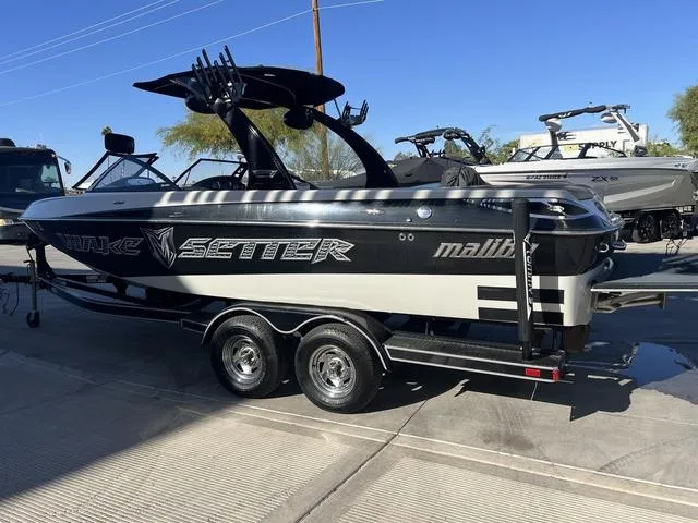 Slide: The Image of 2009 Malibu Wakesetter 23 LSV boat on trailer, black and white design, parked outdoors. - 4