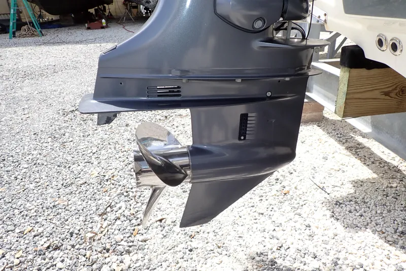 Slide: The Image of 2022 Key West 188 Bay Reef boat motor with shiny propeller on gravel surface. - 42