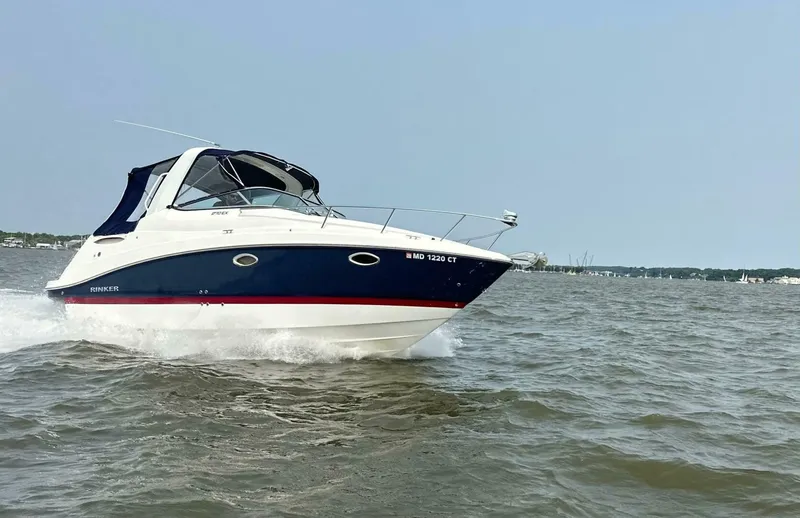 Slide: The Image of 2018 Rinker EX 270 boat cruising on open water under clear skies. - 1