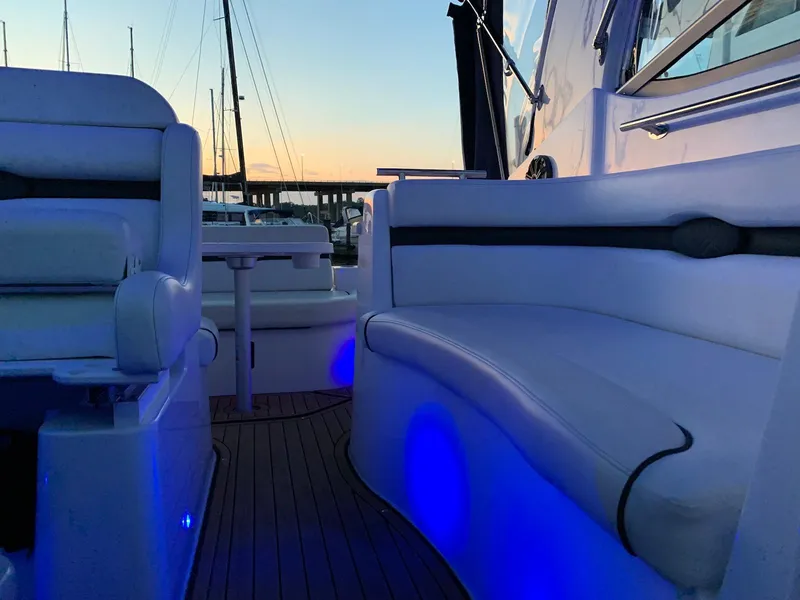 Slide: The Image of 2018 Rinker EX 270 boat interior with blue LED lighting at sunset. - 11