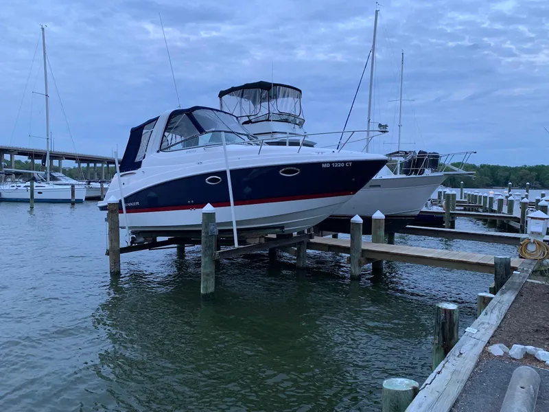 Slide: The Image of 2018 Rinker EX 270 boat docked at a marina under a cloudy sky. - 13