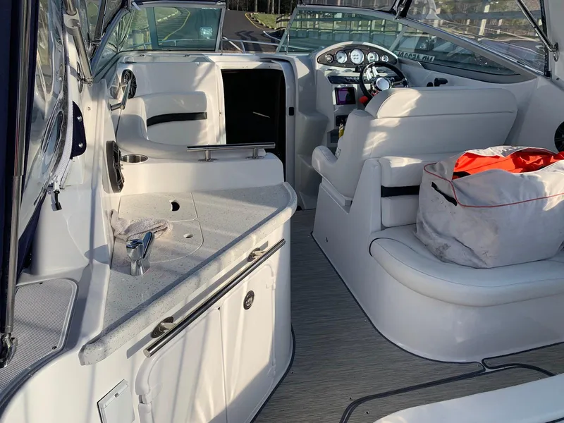 Slide: The Image of 2018 Rinker EX 270 boat interior with seating, dashboard, and storage area. - 16