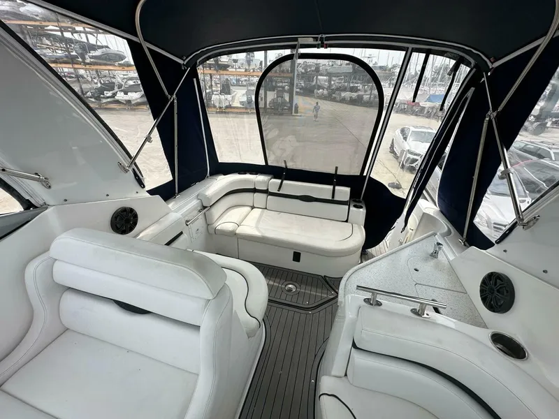Slide: The Image of 2018 Rinker EX 270 boat interior with white seating and canopy, docked at marina. - 20