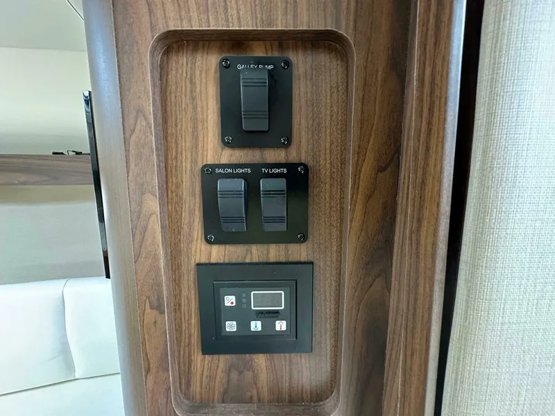 Slide: The Image of Control panel on 2018 Rinker EX 270 boat with switches for galley, salon, and TV lights. - 28