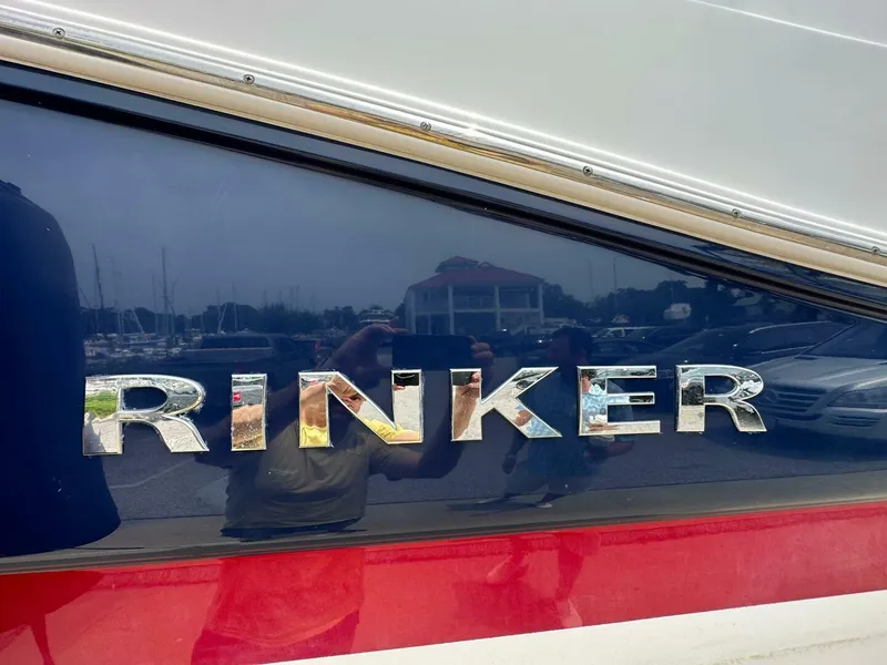 Slide: The Image of 2018 Rinker EX 270 boat with reflective logo and marina background. - 32