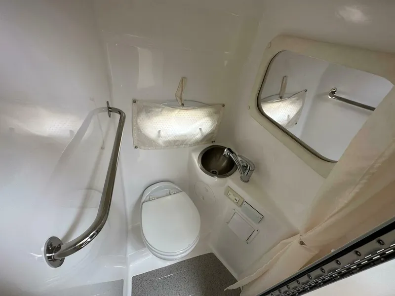 Slide: The Image of 2018 Rinker EX 270 boat bathroom with toilet, sink, and mirror. - 33