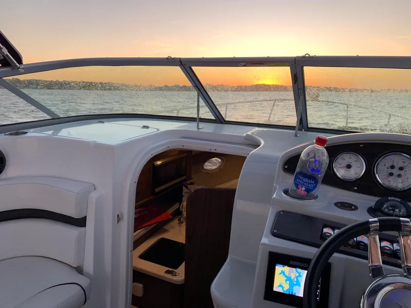 Slide: The Image of 2018 Rinker EX 270 boat interior with sunset view over the water. - 8