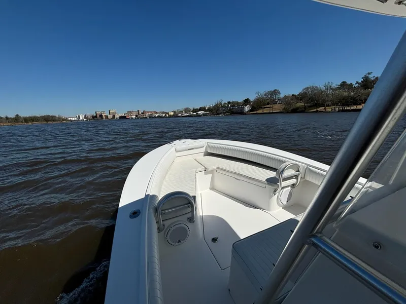 Slide: The Image of 2005 Regulator 24 FS boat cruising on a calm river under clear blue skies. - 6