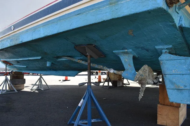 Slide: The Image of Underside of a 1984 Tiara Sport 2700 boat on stands, showing propeller and hull. - 13