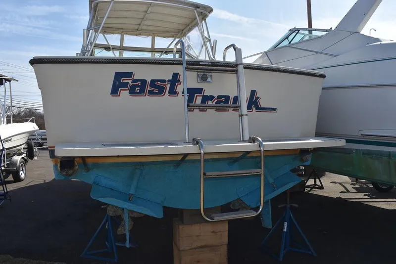 Slide: The Image of 1984 Tiara Sport 2700 boat named "Fast Track" on display with ladder and blue hull. - 16