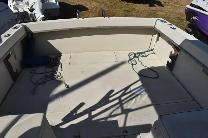 Slide: The Image of 1984 Tiara Sport 2700 boat deck with ropes and shadows, parked on grass. - 19