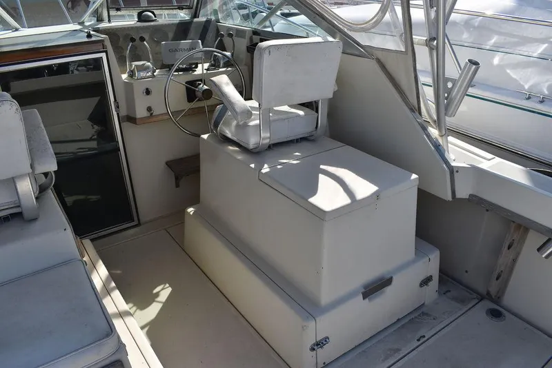 Slide: The Image of 1984 Tiara Sport 2700 boat cockpit with steering wheel and seating. - 20