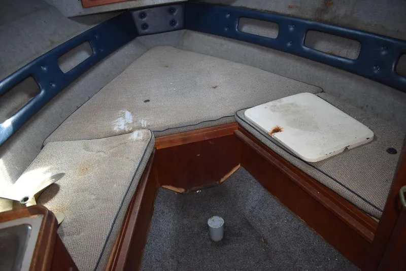 Slide: The Image of 1984 Tiara Sport 2700 cabin interior with worn cushions and wooden accents. - 29