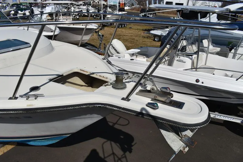 Slide: The Image of 1984 Tiara Sport 2700 boat, docked with other vessels, showcasing deck and railing details. - 3