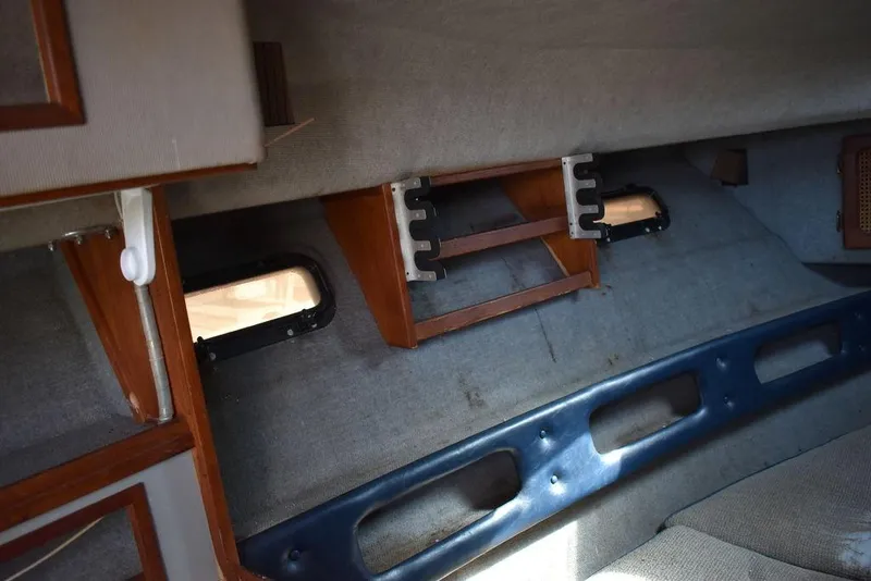 Slide: The Image of Interior of 1984 Tiara Sport 2700 boat, featuring wooden accents and small windows. - 31