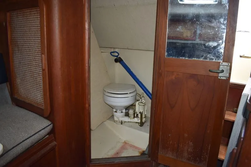 Slide: The Image of 1984 Tiara Sport 2700 boat interior with wooden door and compact marine toilet. - 35