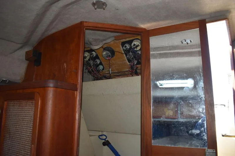 Slide: The Image of Interior of 1984 Tiara Sport 2700 boat showing wooden cabinetry and electrical components. - 36