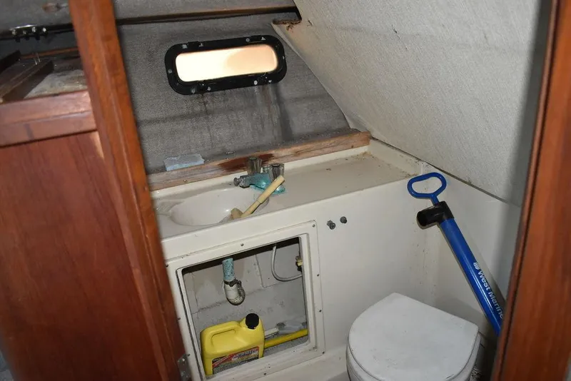 Slide: The Image of 1984 Tiara Sport 2700 boat bathroom with sink, toilet, and storage cabinet. - 37