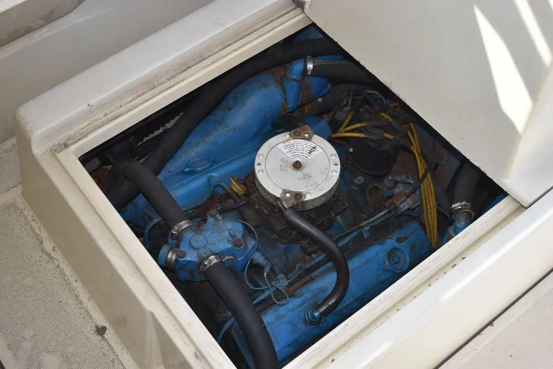 Slide: The Image of Engine compartment of a 1984 Tiara Sport 2700 boat, showcasing blue engine components. - 38