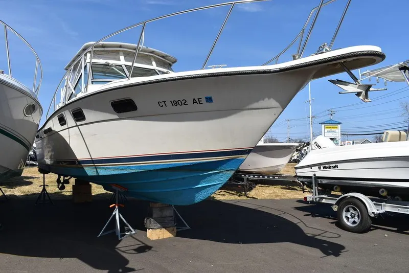 Slide: The Image of 1984 Tiara Sport 2700 boat on display, elevated on stands, with blue hull and white deck. - 6