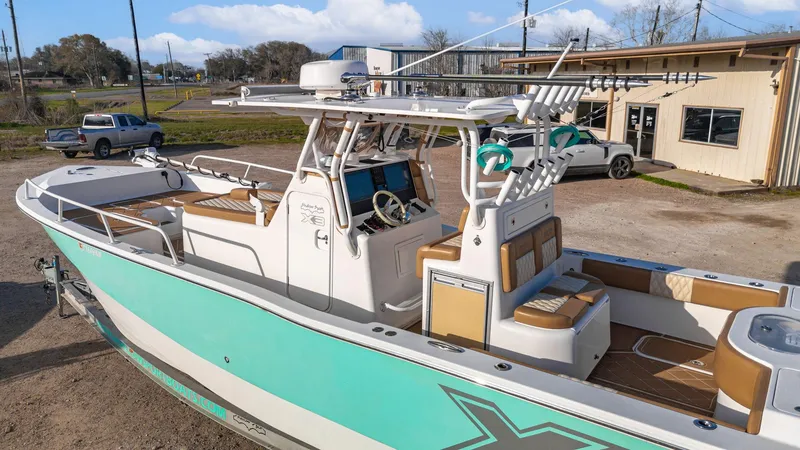 Slide: The Image of 2019 Shallow Sport 32 X3 boat with teal accents, docked outdoors. - 11