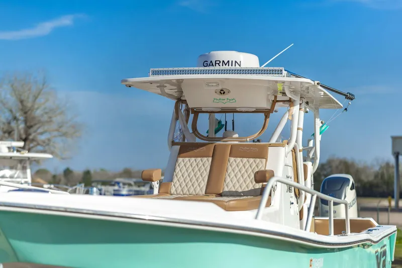 Slide: The Image of 2019 Shallow Sport 32 X3 boat with Garmin equipment, docked under a clear blue sky. - 12