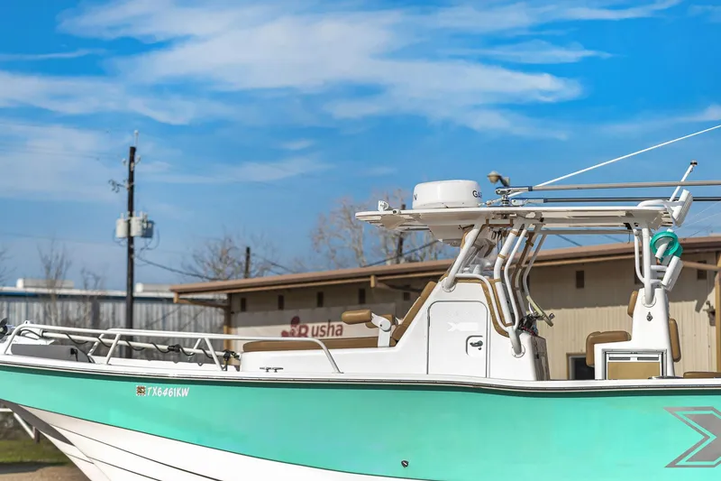 Slide: The Image of 2019 Shallow Sport 32 X3 boat with turquoise hull, docked under a clear blue sky. - 13