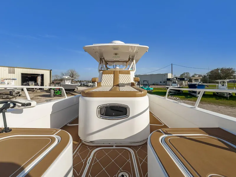 Slide: The Image of 2019 Shallow Sport 32 X3 boat with tan seating and white deck, docked outdoors. - 17