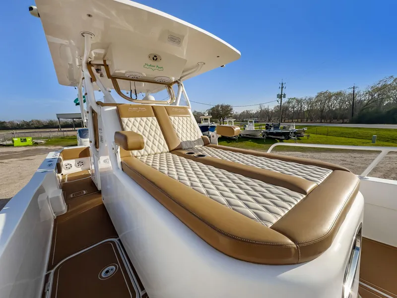 Slide: The Image of 2019 Shallow Sport 32 X3 boat with luxurious tan and white seating, docked outdoors. - 18